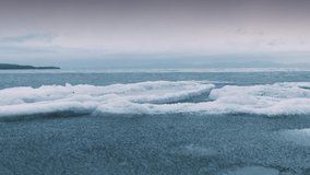 Frozen sea. The north Sea is not completely frozen yet and the ice floes are swaying on the waves. Gloomy weather on the horizon. - Powered by Shutterstock - Get 15% off with code: PIKWIZARD15