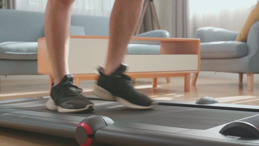 Asian Man Training On Walking Treadmill At Home


