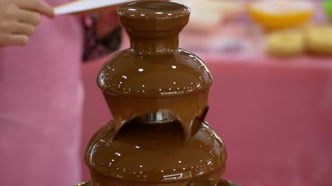 Fountain fondue chocolate placed on a table. Party and celebration by dipped marshmallow in the chocolate fountain.