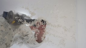 Cleaning the house, housewife using cordless handheld vacuum cleaner, stick vacuum cleaner sucking up rice grits close-up. High quality 4k footage