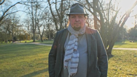selfassured man with scarf and hat looking in soft back light