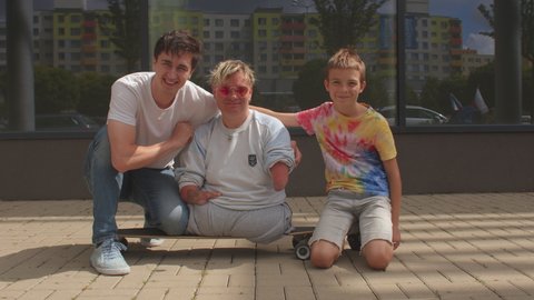 Portrait of happy disabled woman with friends. Congenital amputations. Amelia is absence of a limb, hemimelia is absence of the forearm or hand. CZ, Kladno, Armenska, 4.8.2021. 