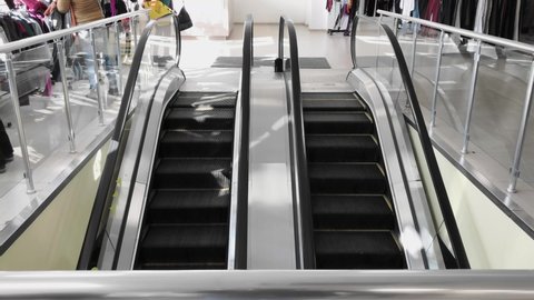 Slow-moving empty escalator inside in shop. No people on elevator stairs. Back to shopping. 