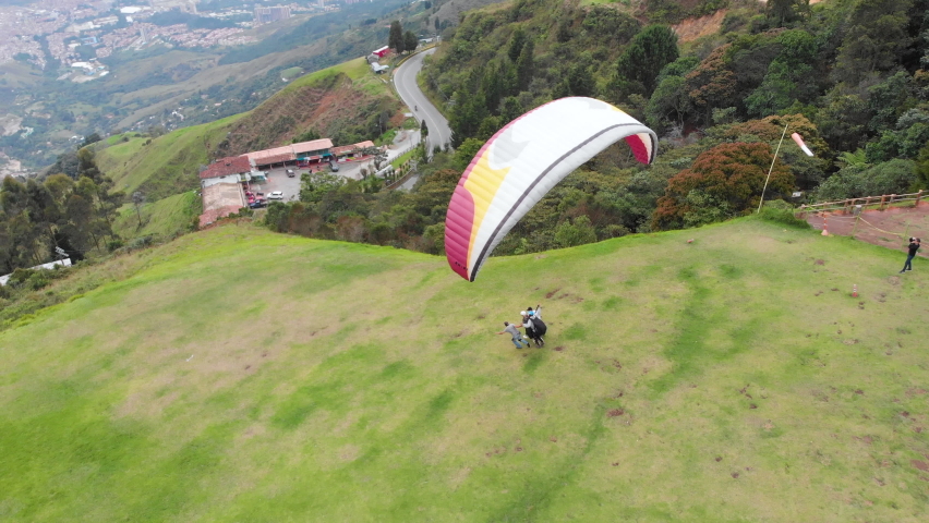Paragliding - Paraglider Take Off From Mountain In Medellin, Colombia. - aerial Royalty-Free Stock Footage #1084184800