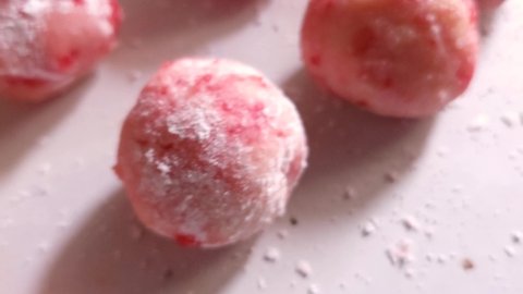 Close up of cherry cordial holiday cookie dough rolled and prepared to bake in the oven. The uncooked dough balls sit on a table. Shot in 4k.