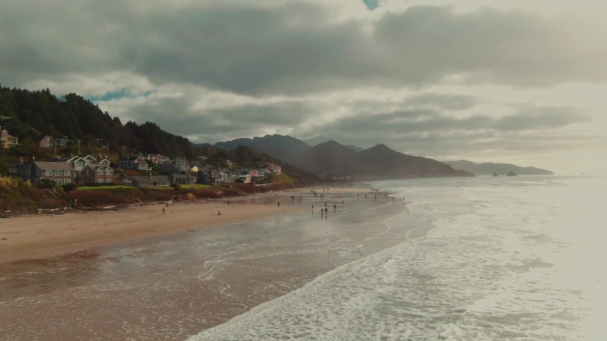 4k Aerial People walking on Oregon beach Drone dolly in