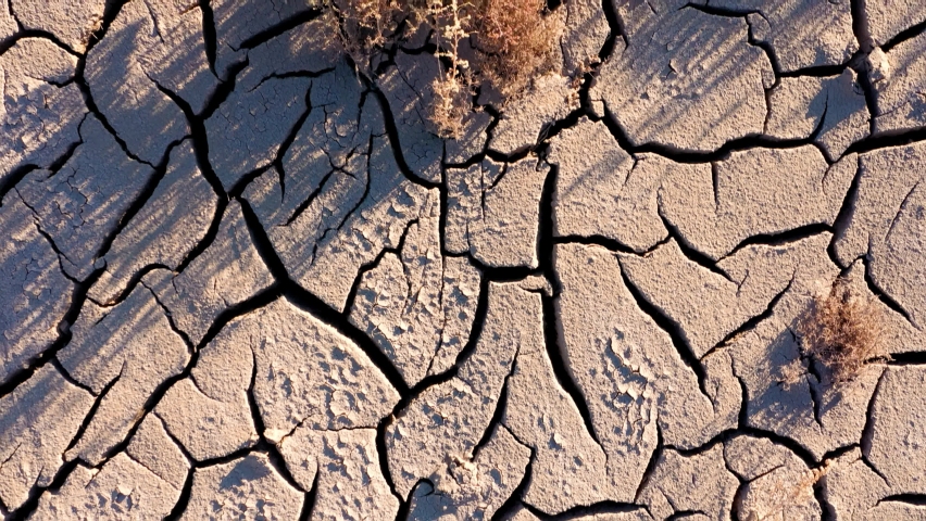 Aerial shot looking down at the cracked surface of a dry river