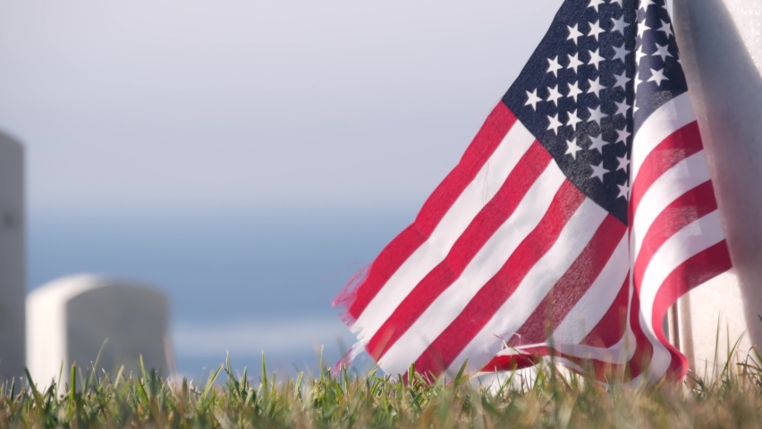 Tombstones and american flag, national memorial cemetery, military graveyard in USA. Headstones or gravestones, green grass. Respect and honor for armed forces soldiers. Veterans and Remembrance Day. Royalty-Free Stock Footage #1084190893