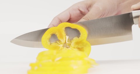 Chef uses a knife to cut yellow bell peppers. Naturally cut into pieces.