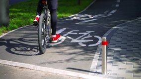 Young boy on a bicycle rides on a bike path in a city park. Bicycles riding in the bike lane. Cycling. Bicycle sign. Riding a bike on an asphalt road.  - Powered by Shutterstock - Get 15% off with code: PIKWIZARD15