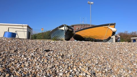 Selsey, West Sussex, UK, December 10, 2021. Two small wooden fishing boats on the shingle beach at Selsey close to the RNLI Selsey Lifeboat Station.