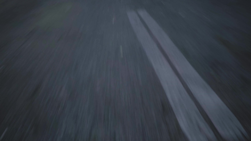 close-up cinematic POV shot of an wet asphalt road. Car is driving on the highway  Royalty-Free Stock Footage #1084199623