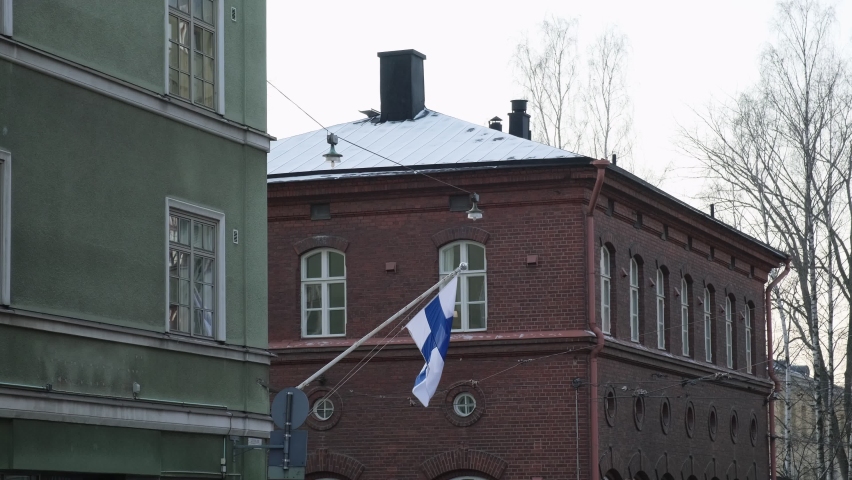 Finnish flag raised for Independence Day in Helsinki street.