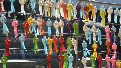 Multicolor colorful paper lamp traditional lanna style Yee peng or lighting lantern tung and flag hanging at outdoor for thai people travel respect praying in Wat Prasat temple of Nonthaburi, Thailand