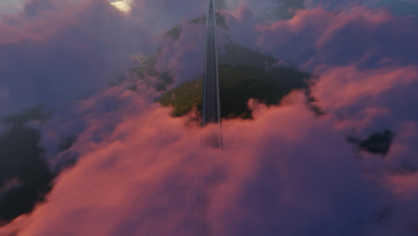 Train in the clouds above the mountains, sunset time, top view