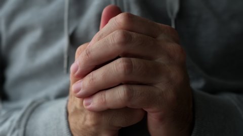 Close up of clasping male hands, adult caucasian man using self-rubbing gestures to dissipate stress