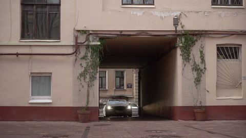 SAINT-PETERSBURG, RUSSIA - JULY, 20, 2021: White luxury sedan Jaguar XJ long car drive in yard of residential building in a city.