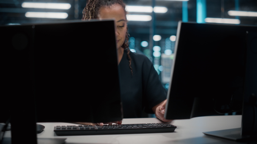 Portrait of African American Female IT Specialist Working on Desktop in Data Center. System Administrator Works on Web Services, Cloud Computing, Server Analytics, Cyber Security Maintenance, SAAS Royalty-Free Stock Footage #1084218085