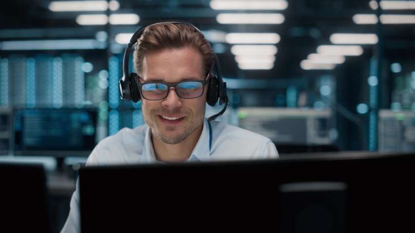 Call Center Office: Portrait of Friendly Caucasian Male Technical Customer Support Specialist Talking on a Headset, uses Computer. Client Experience Officer Helps Online via Video Conference Royalty-Free Stock Footage #1084218136