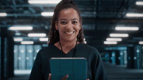Black Female Chief Technology Office Using Laptop Computer, Standing in Big Warehouse Data Center. System Administrator working with SAAS, Cloud Web Services. e-Business Digital Entrepreneur - Powered by Shutterstock - Get 15% off with code: PIKWIZARD15