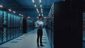 Big Data Center IT Specialist Using Laptop Computer. Server Farm Cloud Computing Facility with System Administrator Working. Software as Solution, Cyber Security. Moving Between Rack Raws Dolly Shot - Powered by Shutterstock - Get 15% off with code: PIKWIZARD15