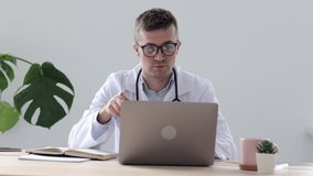 European doctor in a clinic talking to a patient via video link, a Caucasian doctor in an office in a hospital diagnoses a patient via a webcam, telemedicine. doctor-patient communication in