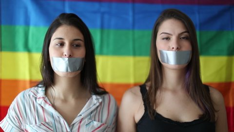 Two women removing mouth tape. LGBT concept