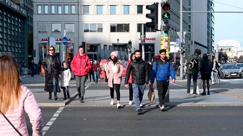 Berlin, Germany, October 2021: People crossing the street. Buildings on Potsdamer Platz. Popular tourist destination in Berlin.