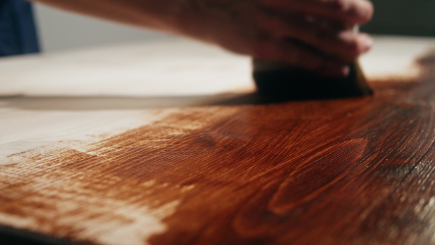 Varnishing wooden table close-up. Painting wood desk in brown, using paintbrush and varnish, making diy furniture. Renovation concept. Building new house or flat. Royalty-Free Stock Footage #1084228696
