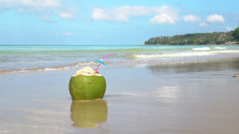 Coconut drink on beach during sunset. Coconut juice with straw tropical island.