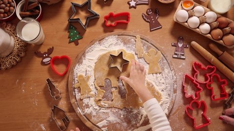 Making gingerbread at home. Little girl cutting cookies of gingerbread dough. Christmas and New Year traditions concept. Christmas bakery. Happy holidays. Top view
