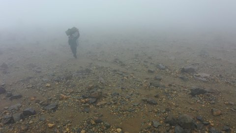 Tanzanian porter team along with guides taking up supplies for a Kilimanjaro expedition as seen from drone (in foggy conditions)