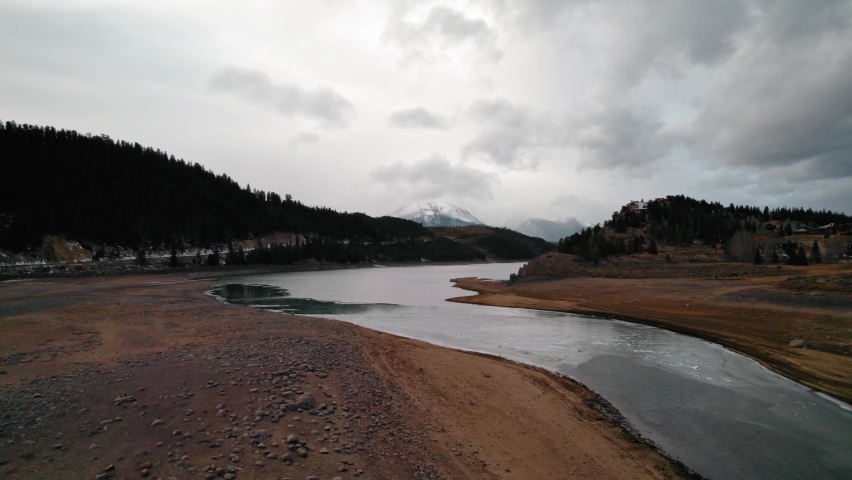 Cloudy Moody Drone Aerial View Of Snake River Arm Water Stream Near Sapphire Point Dillon Reservoir Colorado During Winter.