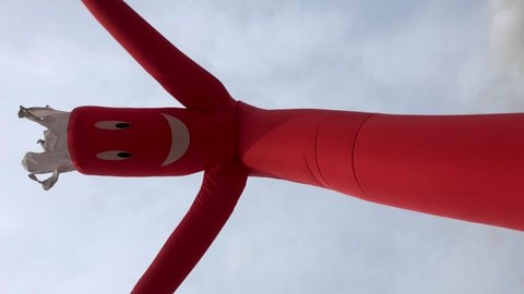 Wacky waving red inflatable tube man on cloudy day slow motion portrait vertical shot