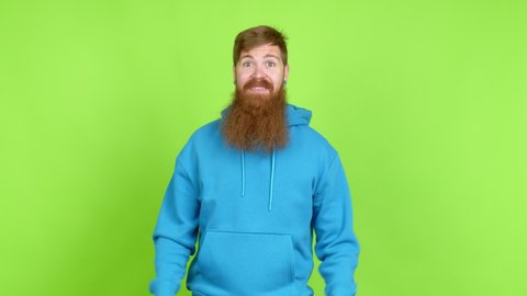 Redhead man with long beard with surprise and shocked facial expression over isolated background