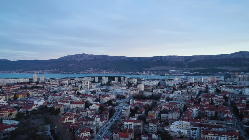 Vibrant city of Split with massive mountain range in background, aerial drone shot