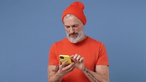 Sad irritated elderly gray-haired bearded man 50s wears red t-shirt hat using mobile cell phone swear hears fake news unexpected rumor isolated on plain pastel light blue background studio portrait - Powered by Shutterstock - Get 15% off with code: PIKWIZARD15