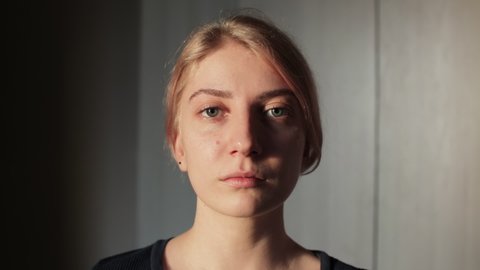 Portrait of a sad young woman looking to the camera, close up