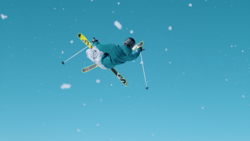 SLOW MOTION, CLOSE UP Action shot of an expert freestyle skier taking off a kicker and doing a 360 grab while exploring Vogel, Slovenia. Skier riding in the mountains of Slovenia does a cool trick. | Shutterstock HD Video #1084262038