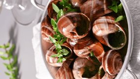 Grilled snails , cooking barbecue seafood with pesto sauce. French cuisine. Vertical video, ideal for social media and smartphones. 4 k