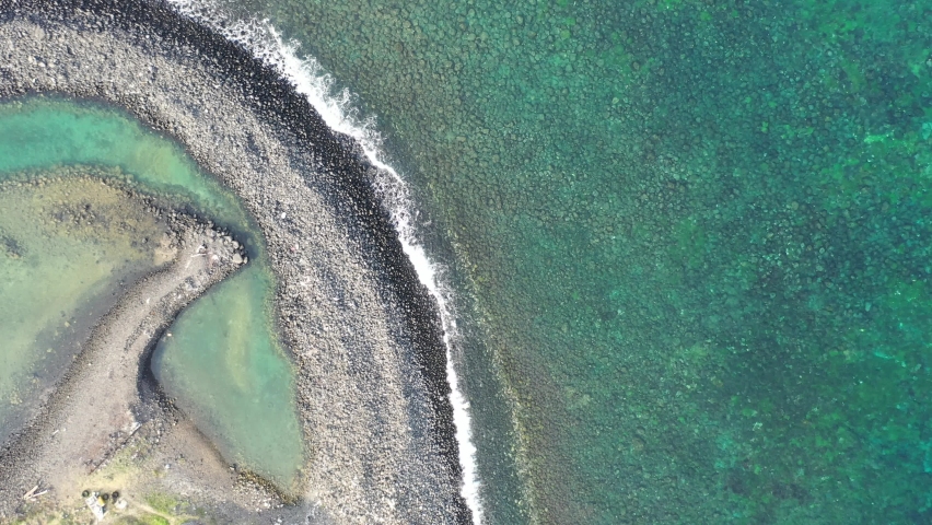 Top down view of the Double-Heart of Stacked Stones or the Twin-Heart Fish Trap bathed in the beautiful sea water, which is a fishing weir and now a popular tourist attraction in Cimei, Penghu, Taiwan Royalty-Free Stock Footage #1084270972