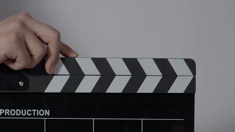 Clapper board. Close up hand and film making clapperboard isolated on background studio. Movie or video production concept. Clappers board Shuts. Film crew holds film slate in hand for video recording