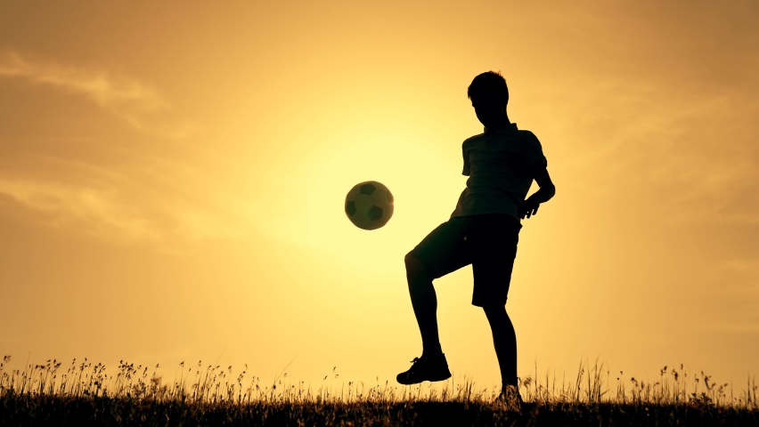 Boy with soccer ball. Child in park plays at sunset.Boy juggles soccer ball.Child dream of football match.Sports training in park. Sportsman is in control of ball. Child juggles ball.Healthy lifestyle | Shutterstock HD Video #1084282096