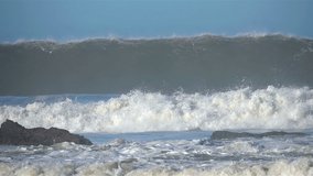 Extreme Ocean Wave crushing coast. Power of waves breaking splashing sea-spray water foam