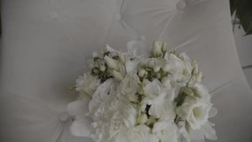 Bride wedding morning. Bride`s boidoir. Delicate beige shoes and a wedding bouquet on a chair. Bride's accessories. Wedding details. Slow motion video.