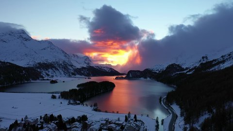 Dramatic sunset over the Sils Segl Maria village by the lake Sils in winter in the Engadine valley in Canton Graubunden in the Swiss alps. Shot with a cinematic rotation motion