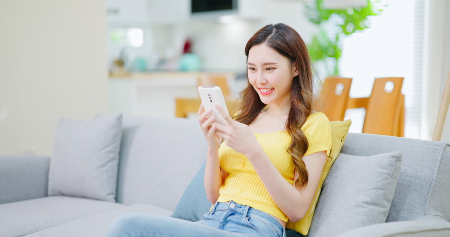 asian woman earns cryptocurrency from NFT mobile game at home Royalty-Free Stock Footage #1084294741