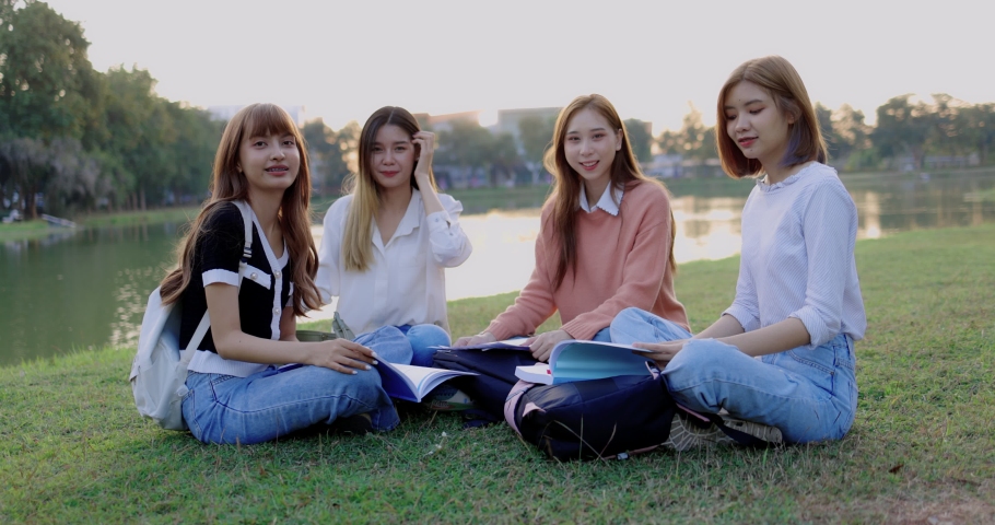 Group of Asian college student girl friends are sitting in the park together.