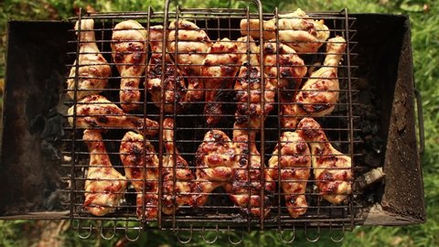 Fried chicken legs on a grill in the summer outdoors. Delicious meat with a crust, outdoor recreation, close-up