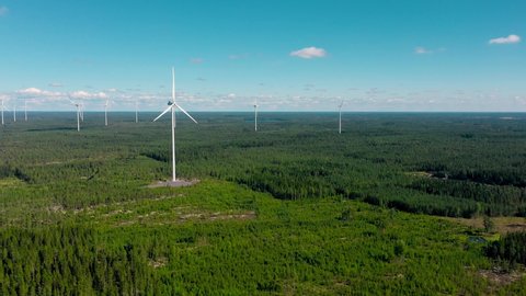 Aerial view around a windmills, sunny summer day in Finland - panoramic, circling, drone shot